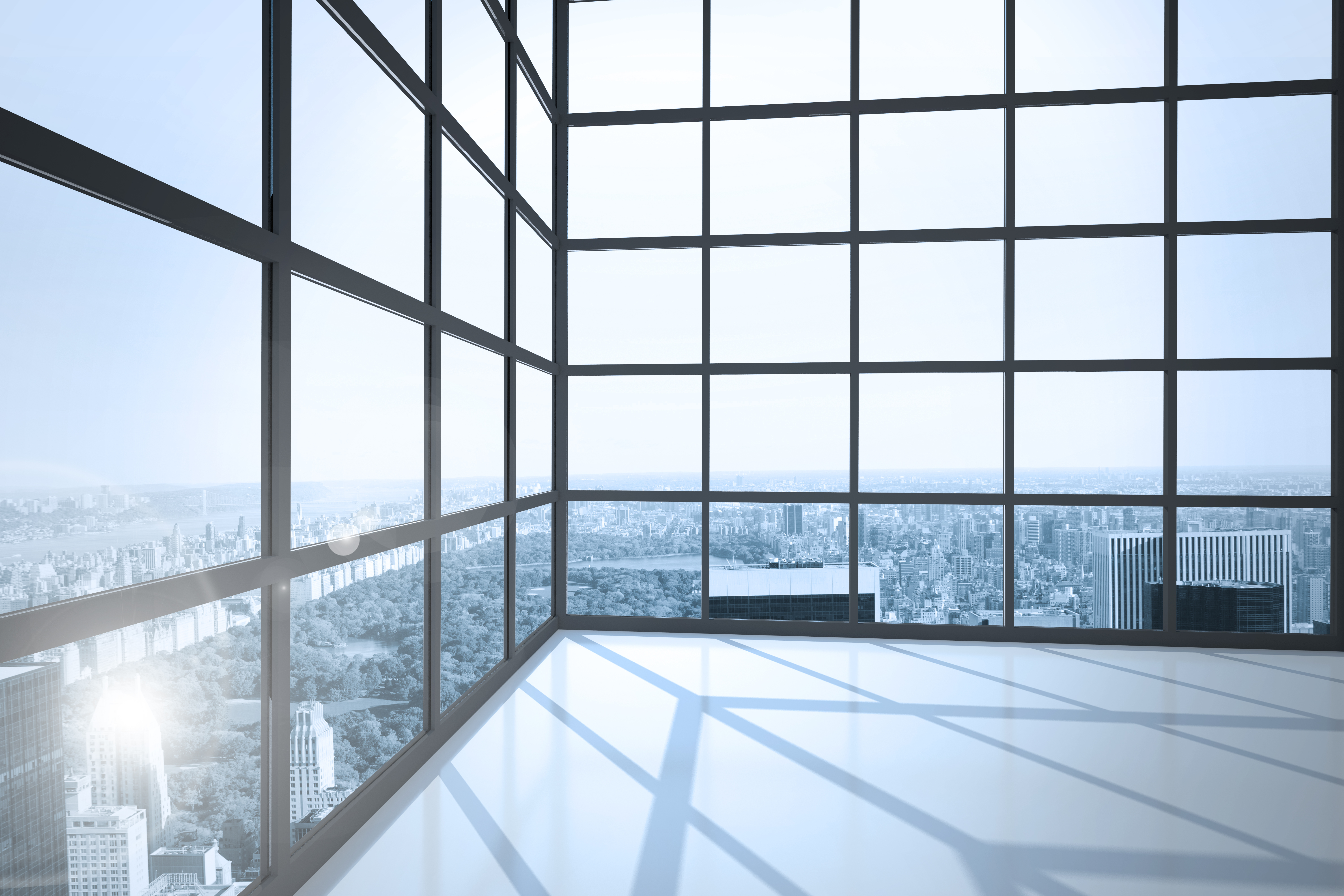 Room with large windows showing city